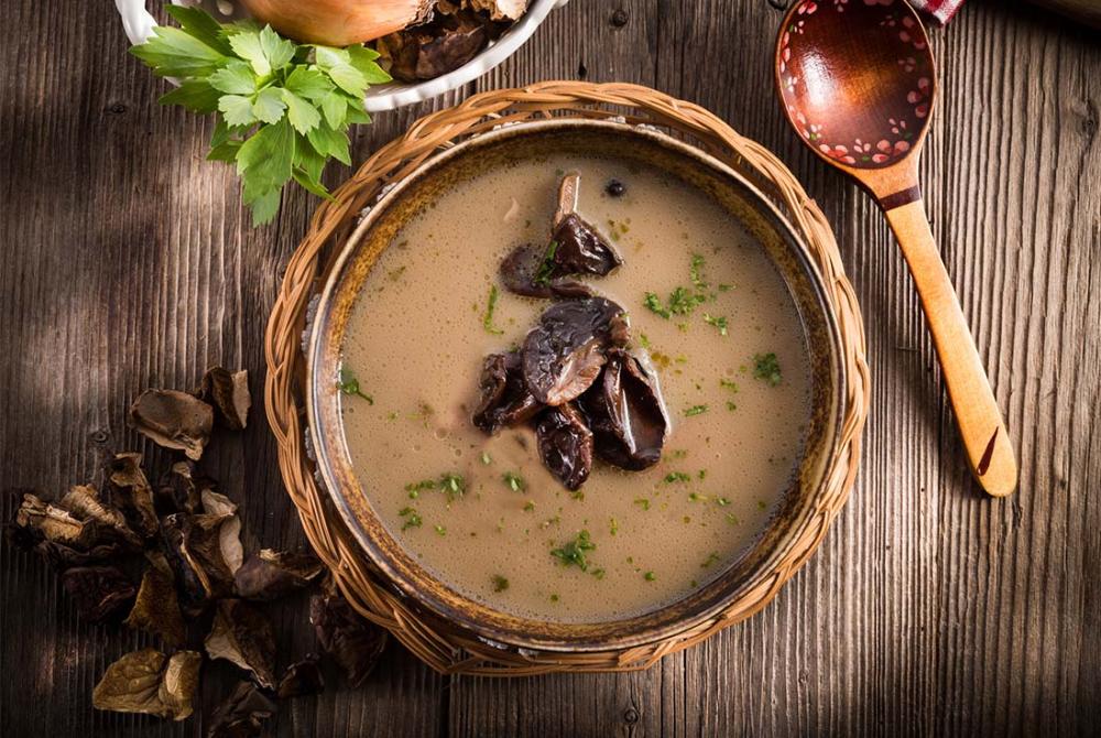 Gros plan sur le velout&eacute; de champignons montrant sa texture onctueuse et cr&eacute;meuse, d&eacute;cor&eacute; de cerfeuil et de muscade.