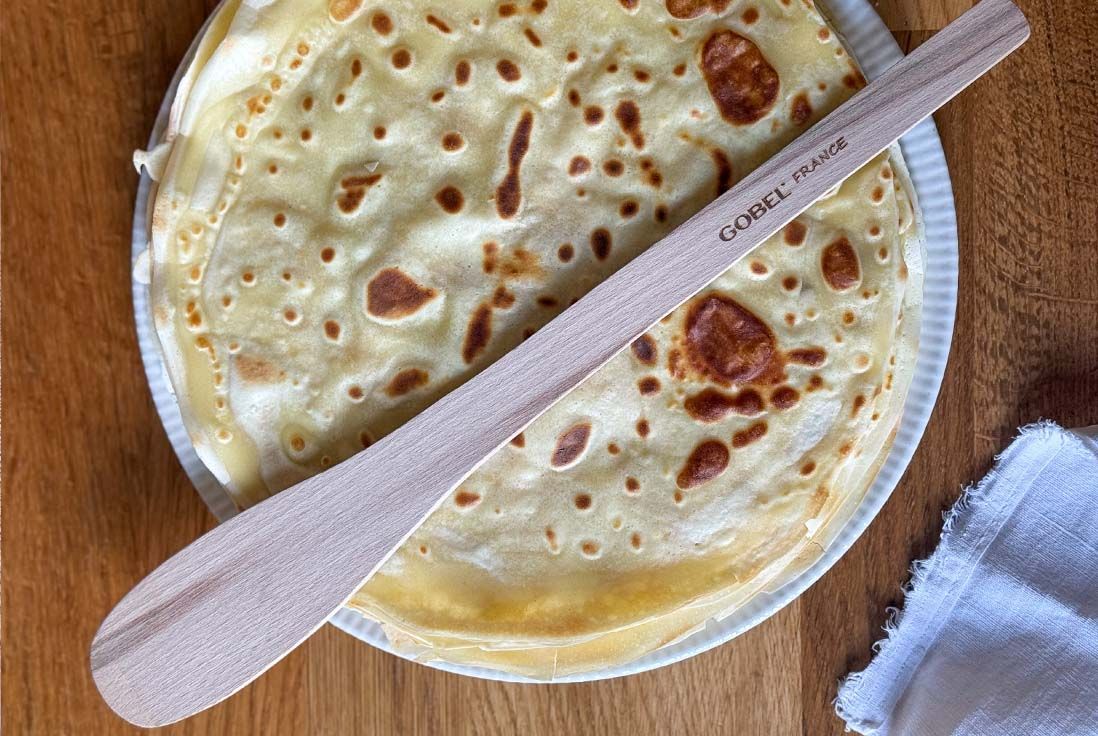 Image d'une pile de crepes à déguster posées sur une table en bois