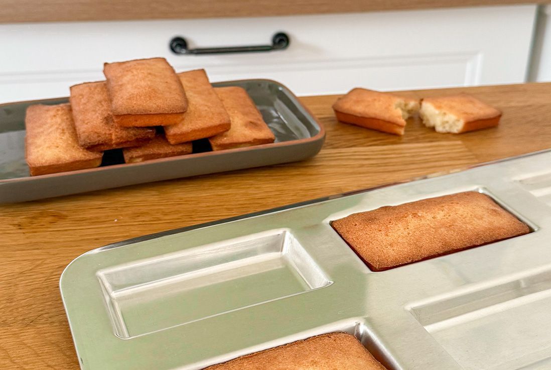 Image de financiers et de la plaque gobel à financiers posée sur un plan de travail en bois