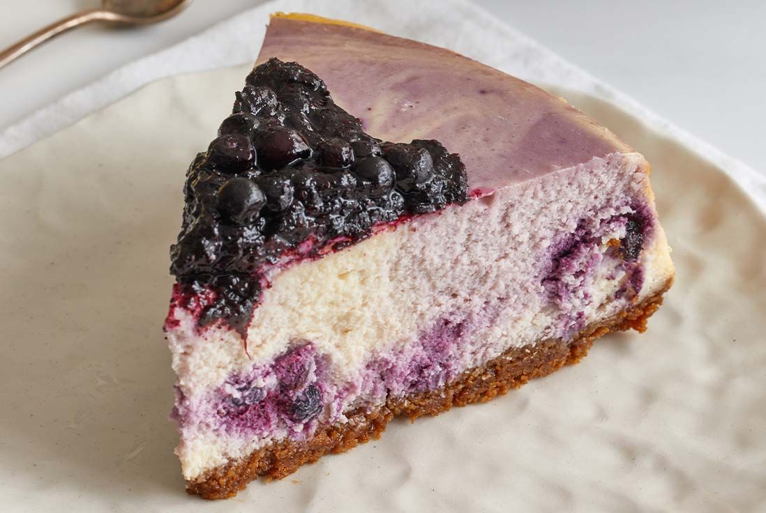 image d'une part de cheesecake à la myrtille dans une assiette