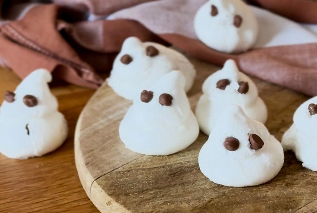 Visuel de meringues en forme de fantôme posées sur une planche en bois