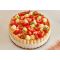 Une charlotte aux fraises maison posée sur une table, garnie de crème pâtissière pochée, de quartiers de fraises fraîches et de petites feuilles de menthe, entourée de biscuits à la cuillère maintenus par un ruban blanc