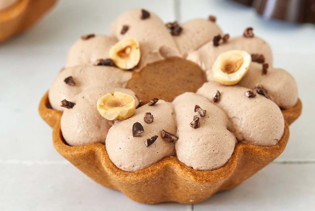 image d'une tartelette en forme de fleur à la noisette et chocolat au lait pochée en ganache montée