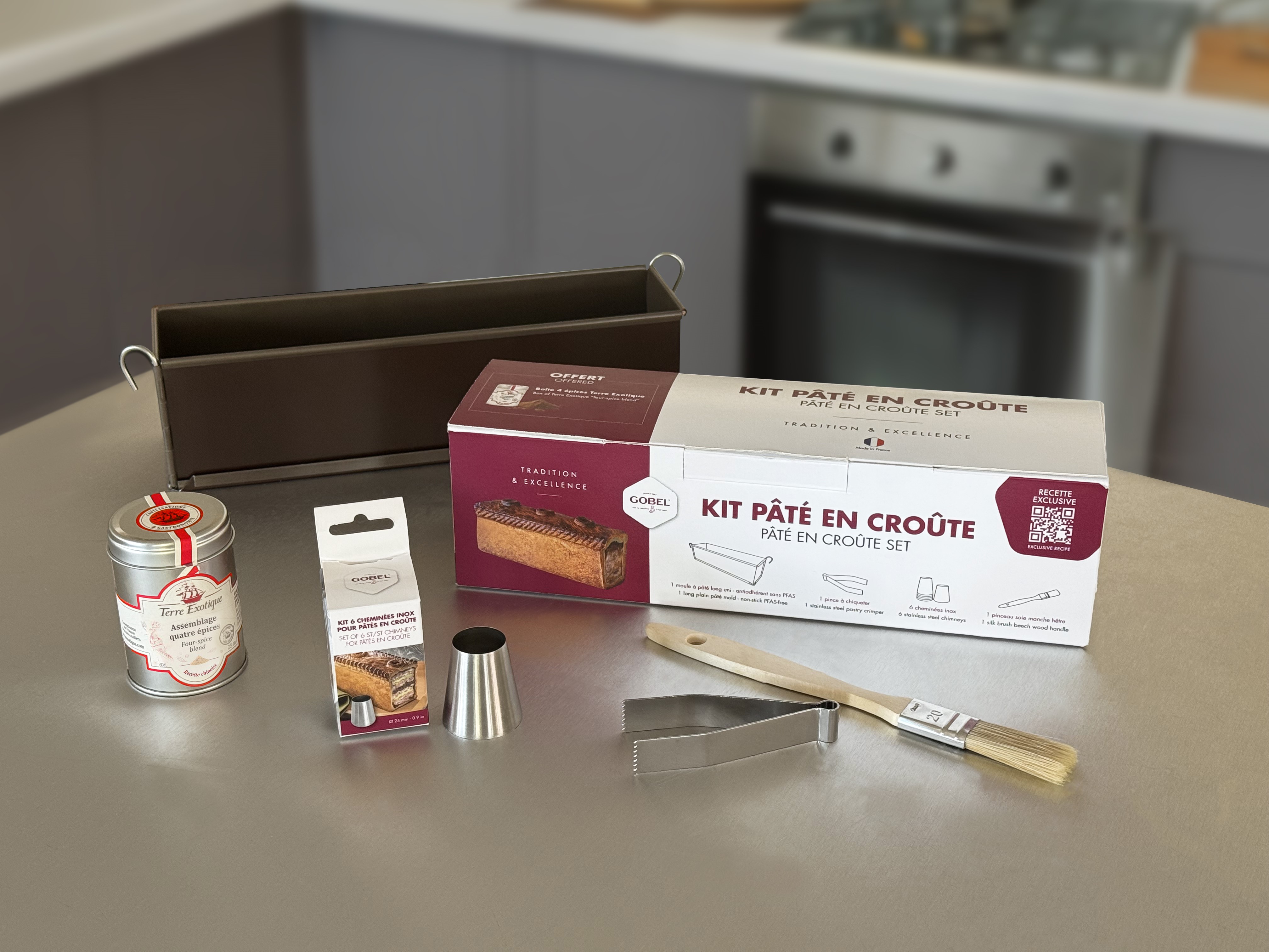 image du kit Pâté en croûte Louis Tellier posé sur une table en inox avec ses accessoires et mélange épices